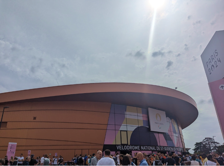 A crowd is pictured outside entrance at at The Vélodrome National de Saint-Quentin-en-Yvelines on a cloudy day.