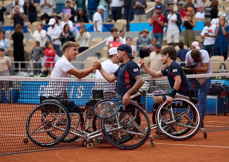 GB & Dutch Men’s Quad Doubles Paralympians shake hands over the net in front of a crowd of spectators at the Philippe Chatrier centre court at Paris’s Roland-Garros Stadium